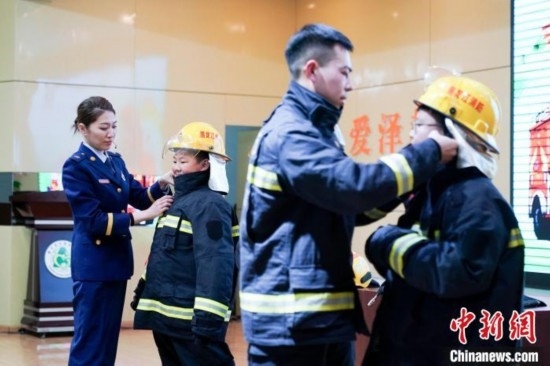 圖為學(xué)生們現(xiàn)場(chǎng)穿戴消防頭盔和戰(zhàn)斗服。中新社記者 趙宇航 攝