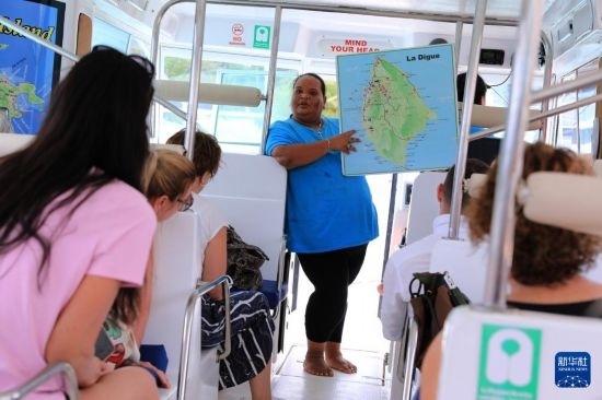 3月15日，一名導(dǎo)游在游艇上為游客介紹塞舌爾拉迪格島。新華社記者 董江輝 攝