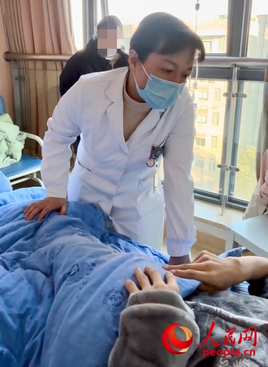 鄧茜查房時(shí)詢問患者情況。人民網(wǎng)記者 金慧慧攝