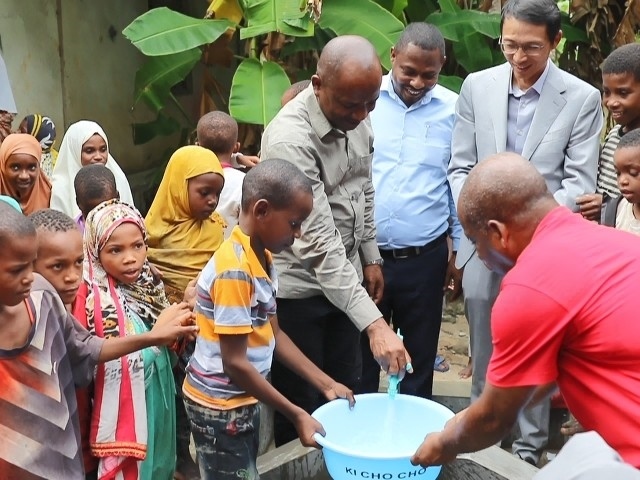 在日前舉行的安全供水工程揭牌儀式上，當(dāng)?shù)匦∨笥言诠┧c(diǎn)接水。 施亮攝