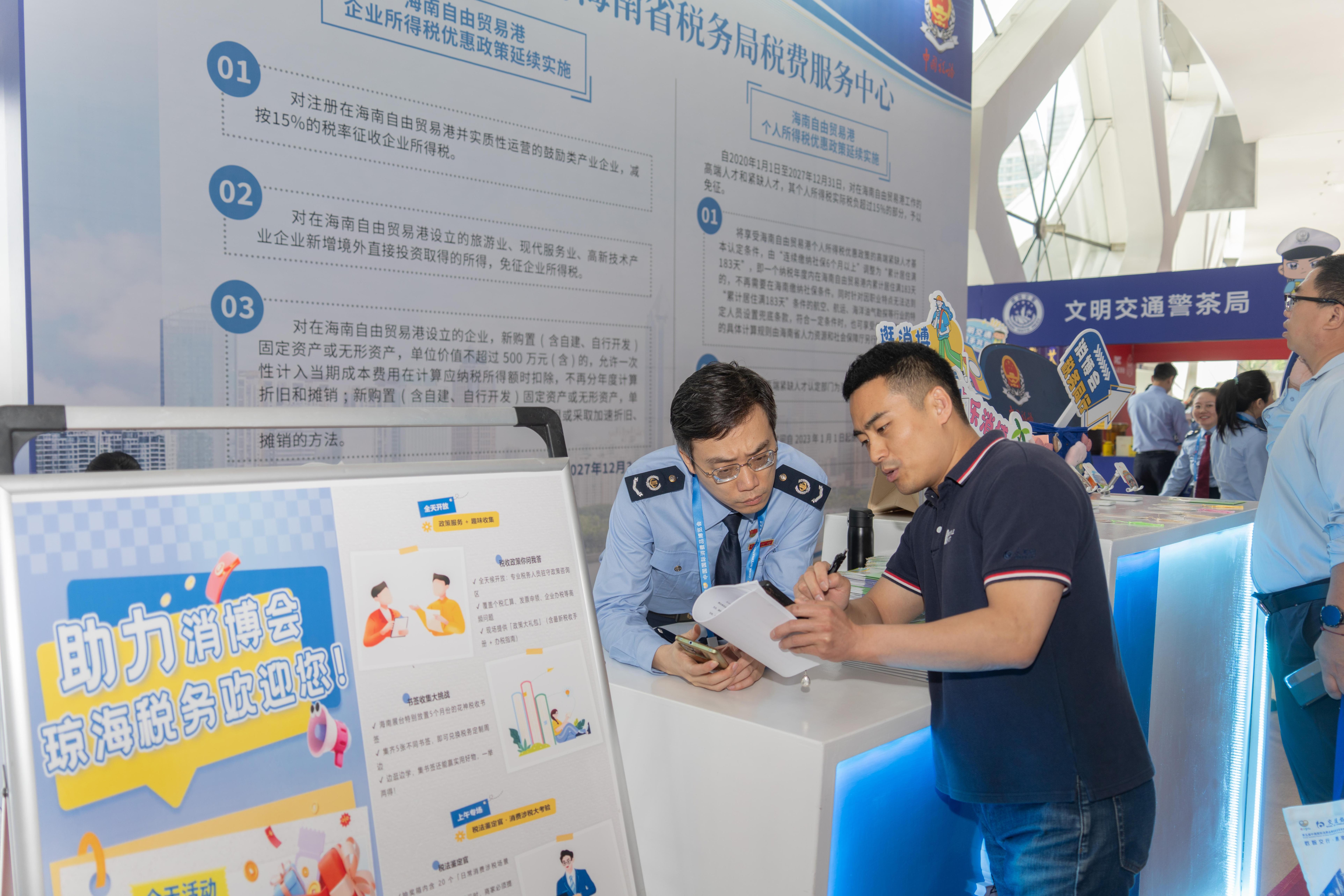 稅務(wù)服務(wù)臺工作人員向記者介紹服務(wù)參展外商的具體舉措。人民網(wǎng)記者 許崢攝