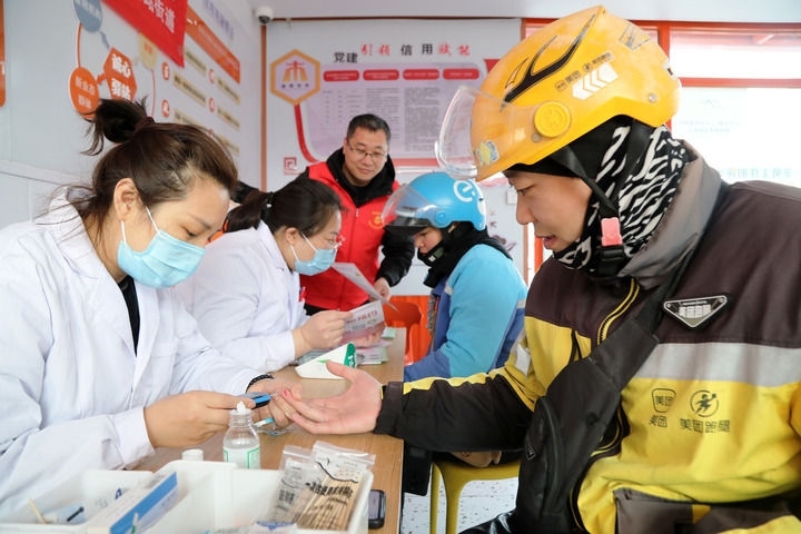 2025年3月5日，志愿者在山東省棗莊市市中區(qū)一工會驛站為外賣員免費測量血糖。新華社發(fā)（王海楠攝）