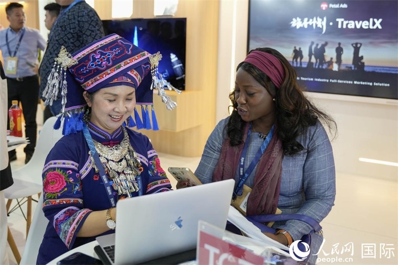 來(lái)自廣西的旅游業(yè)者同客戶交流。人民網(wǎng)塔里克·易卜拉欣攝