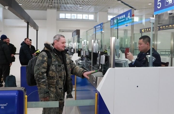 2024年12月10日，在黑河公路口岸旅檢大廳，黑河出入境邊防檢查站民警為首班次客車入境旅客辦理邊檢通關(guān)手續(xù)。當(dāng)日，中國黑河公路口岸—俄羅斯卡尼庫爾干公路口岸旅客運(yùn)輸正式開通。新華社發(fā)（劉松攝）