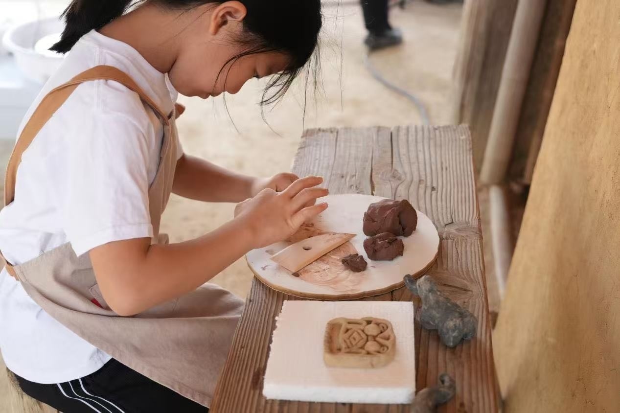 游客制作良渚特色陶藝品。良渚博物院供圖