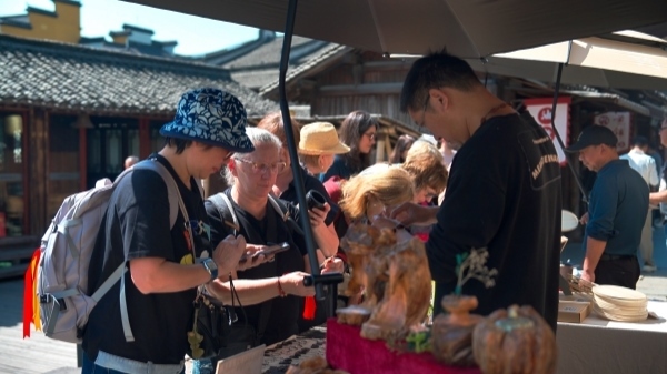 “五一”期間，游客正在烏鎮(zhèn)“水鄉(xiāng)碼頭”挑選購買文創(chuàng)產(chǎn)品。受訪者供圖