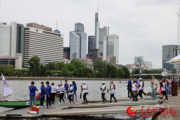來(lái)自美國(guó)的快樂龍舟隊(duì)選手們正在登船準(zhǔn)備參賽。人民網(wǎng)記者 劉仲華攝