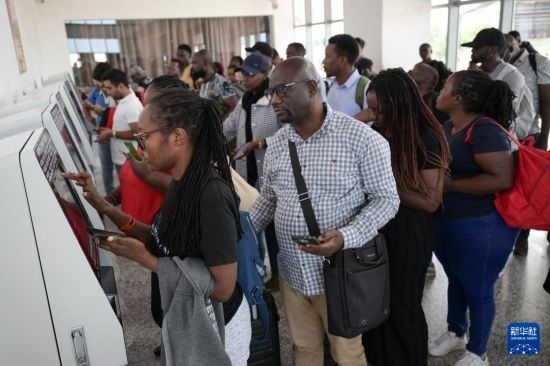 5月31日，在蒙內(nèi)鐵路內(nèi)羅畢站，乘客在自助取票機(jī)前排隊(duì)取票。新華社記者 楊光 攝